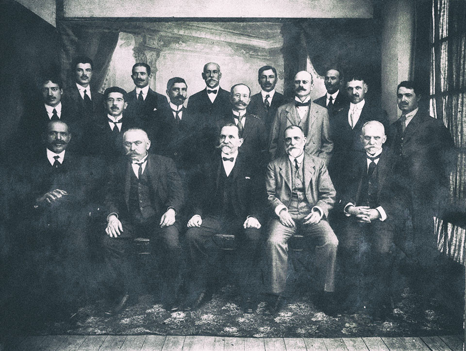 Χίος, Μάιος του 1917. Καθηγητές της μέσης εκπαίδευσης. Καθιστοί από αριστερά : Χ.Λαγούτης, Α.Ασπιώτης, Χ.Αλιμονάκης (γυμνασιάρχης του Γυμνασίου Αρρένων), Γ.Ρεβελής (ιδρυτικό μέλος και επί σειρά ετών πρόεδρος του Φιλοτεχνικού Ομίλου Χίου), Εμμ.Ιωαννίδης. Ο Μίλτος Κουντουράς πρώτος από αριστερά στη δεύτερη σειρά. Φωτογράφος : Στάμος Χαρτουλάρης, Χίος.